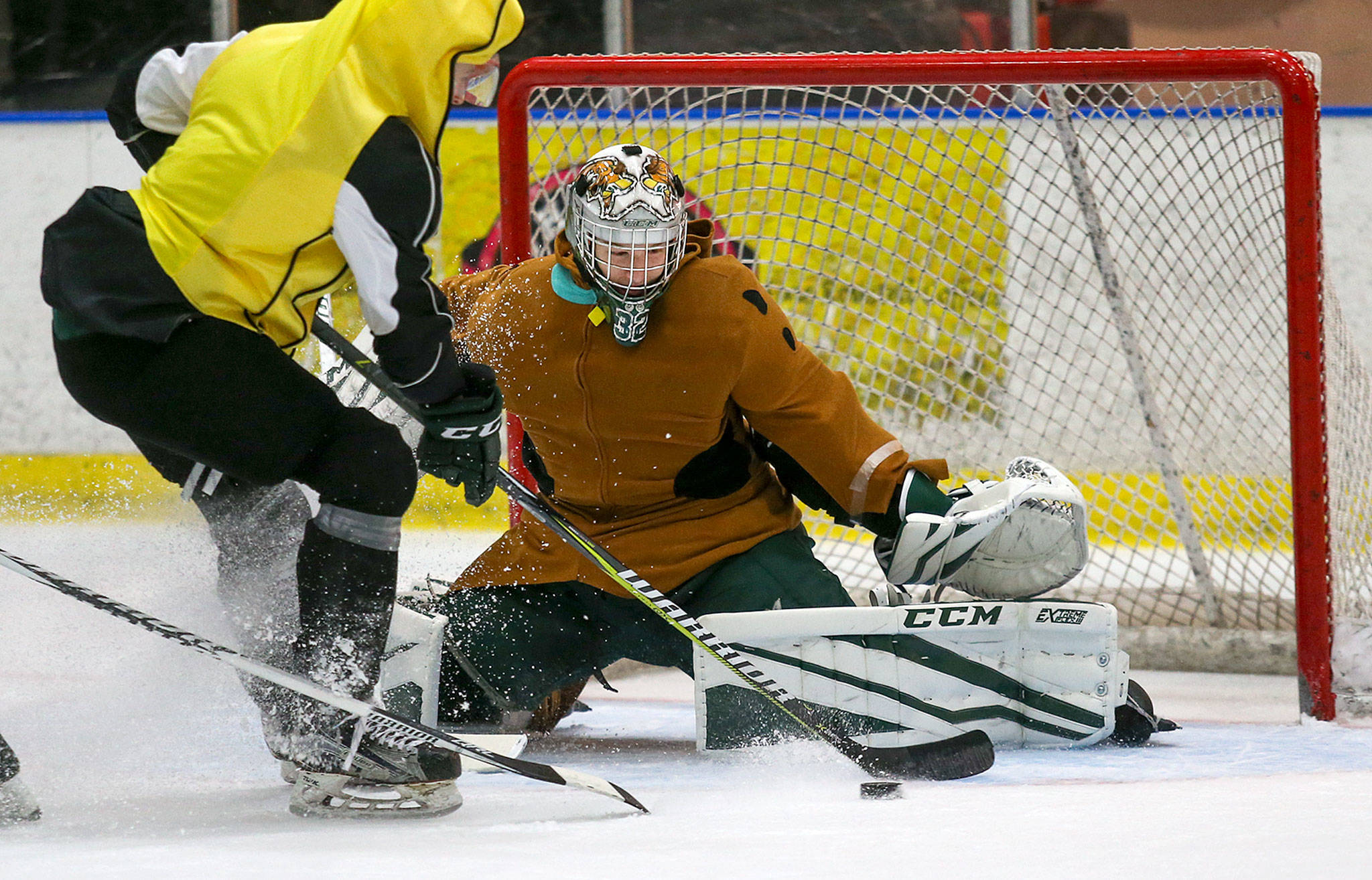 Silvertips goalie Dustin Wolf, donning a Scooby-Doo costume, keeps an eye on the puck during practice on Halloween in Everett. (Andy Bronson / The Herald)