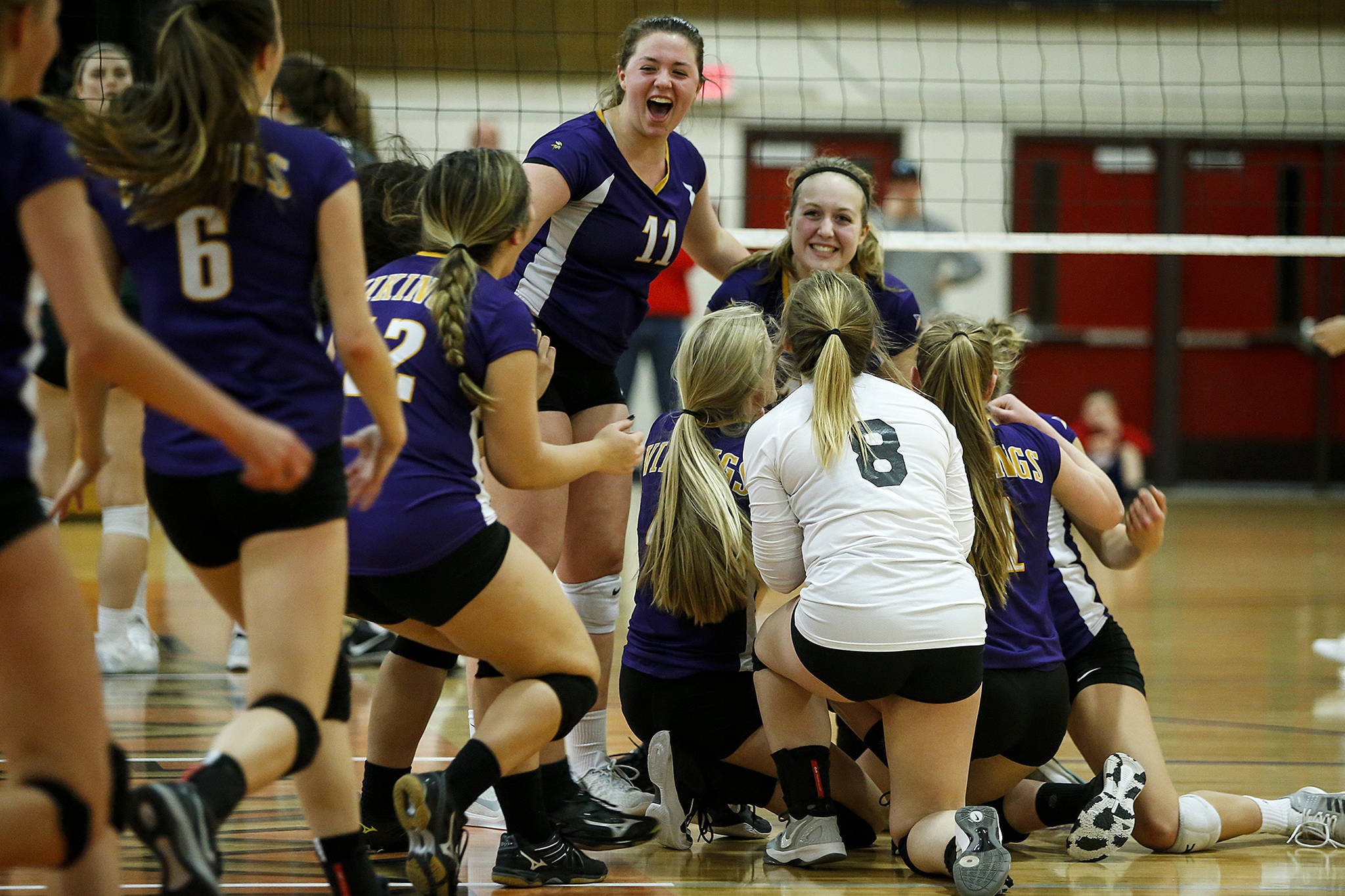 The Lake Stevens volleyball team celebrates its victory over Jackson in the 4A District 1 championship match on Thursday at Marysville Pilchuck High School. The Vikings clinched a state tournament berth with the three-set sweep. (Ian Terry / The Herald)