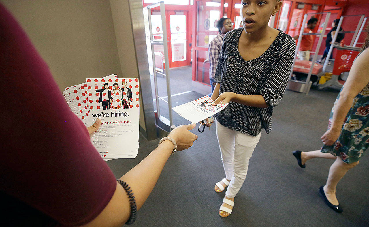 A potential job candidate takes a flyer from a human resources representative at a Target store in Dallas on Oct. 13. (AP Photo/LM Otero)