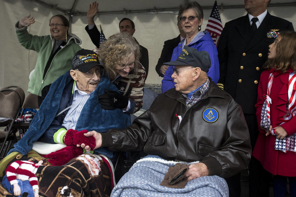 Jim Greimes (right), of Redmond, meets fellow World War II veteran Preston Scheid, of Edmonds, during the Mill Creek Veterans Day parade on Saturday. Scheid will be turning 100 years old this March. (Ian Terry / The Herald)
