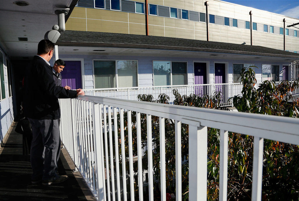 Joe Alonzo (left), interim CEO of Cocoon House, talks with the nonprofit’s public relations manager, Julio Cortes, on the upper walkway at the Pine Street facility, which can house 20 kids. (Dan Bates / The Herald)
