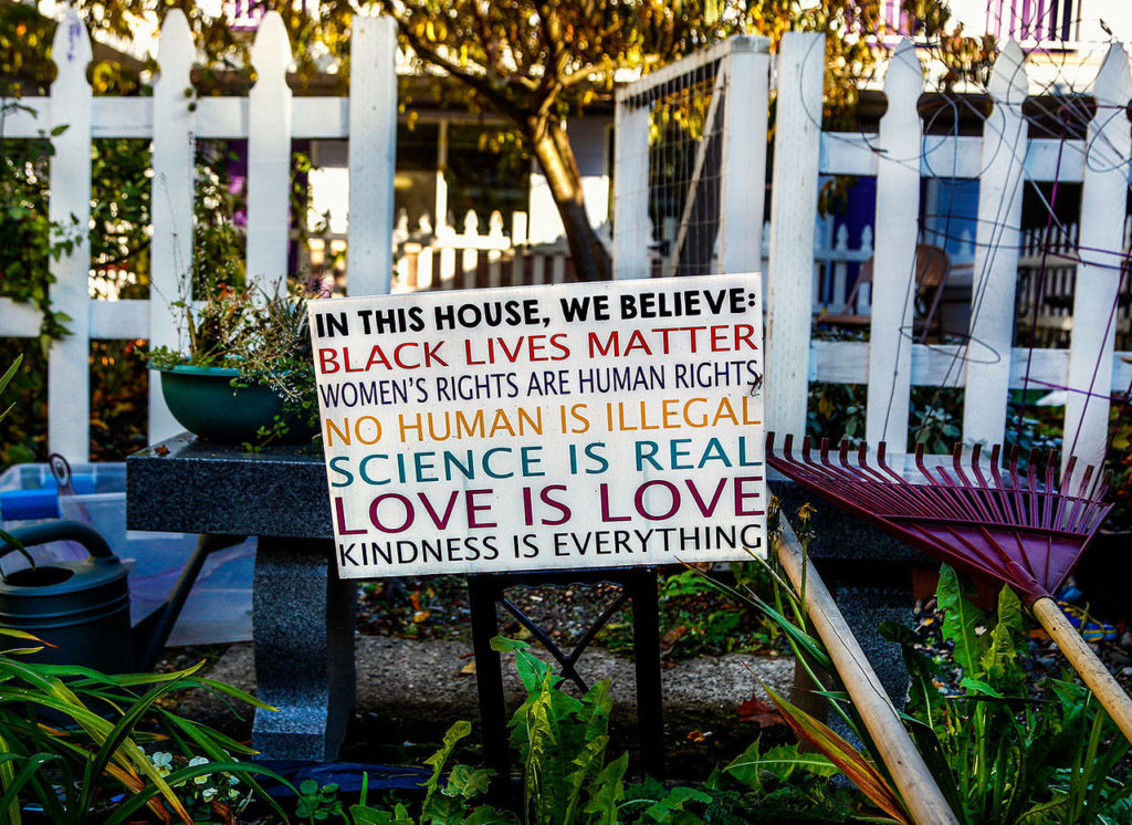 Just outside the gate to the communal garden at the Pine Street Cocoon House, a sign conveys the agency’s unconditional acceptance. (Dan Bates / The Herald)
