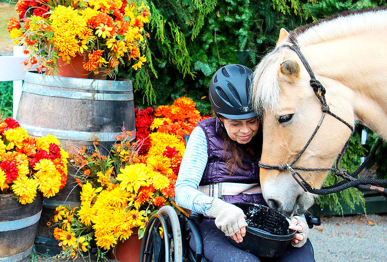 Judy Smith nuzzles with her horse after a session at Equestrian Crossings, a program providing therapeutic horsemanship. Smith travels from Seattle every Wednesday to ride with the Coupeville program. (Patricia Guthrie/Whidbey News-Times)