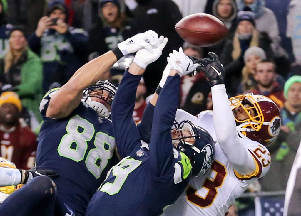 Seahawks tight end Jimmy Graham (88) and wide receiver Tanner McEvoy jump for a Hail Mary pass with Redskins safety DeAngelo Hall on the final play Sunday. The pass fell incomplete.. (Kevin Clark / The Herald)
