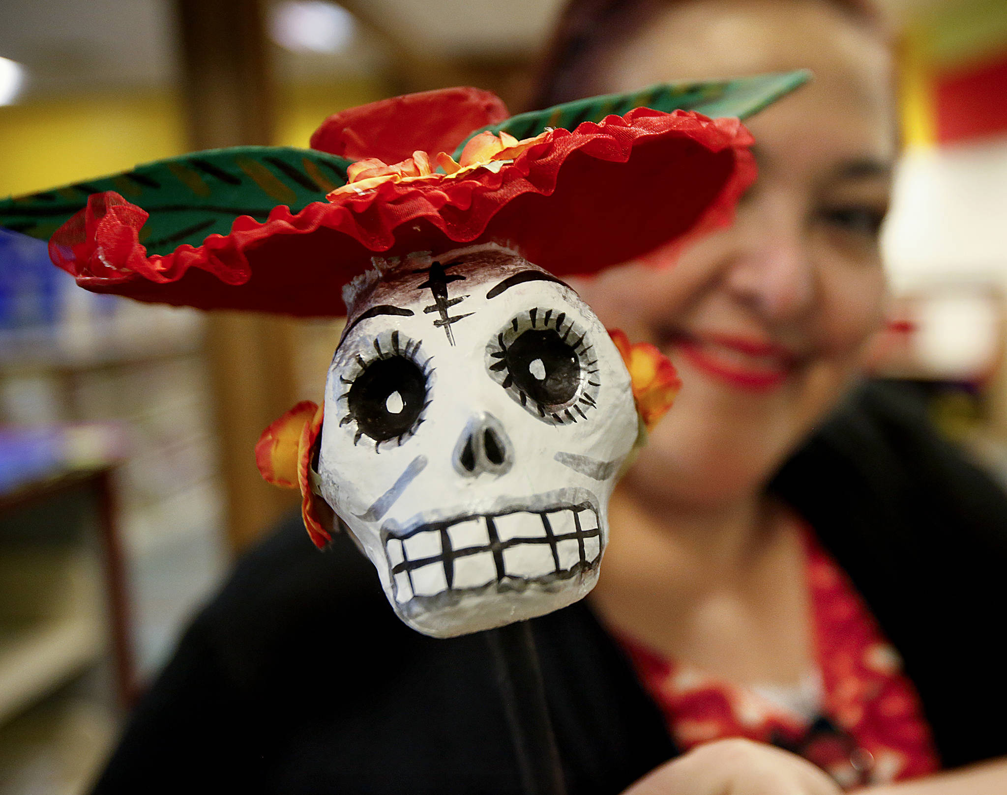 Lupita Zamora helps set up a Dia de los Muertos display in the Lynnwood Library on Halloween. (Dan Bates / The Herald)