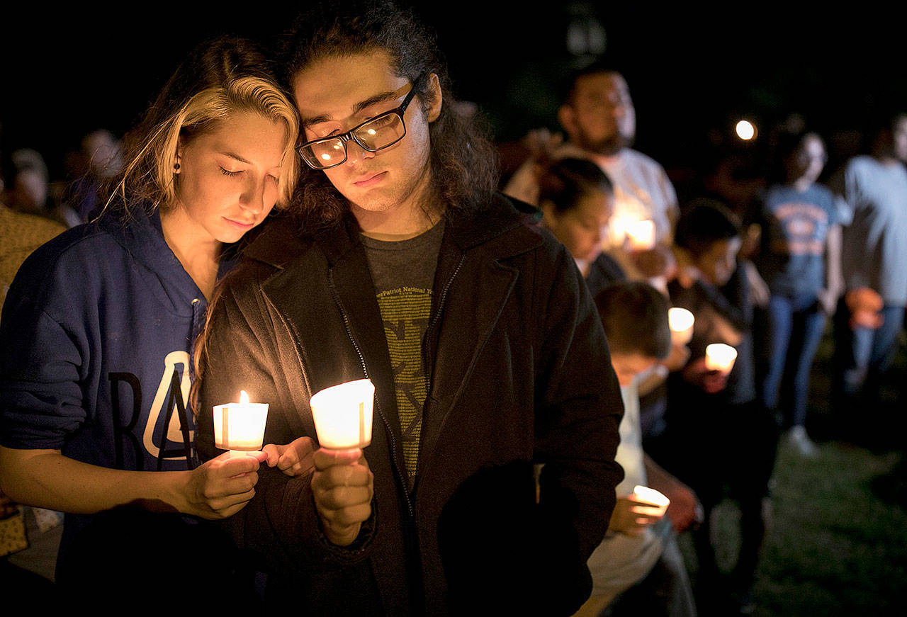 Bailey LeJeaune, 17, and David Betancourt, 18, hold candles during a vigil in Sutherland Springs, Texas, for the victims of a deadly shooting at the First Baptist Church there on Sunday. (Jay Janner/Austin American-Statesman via AP)