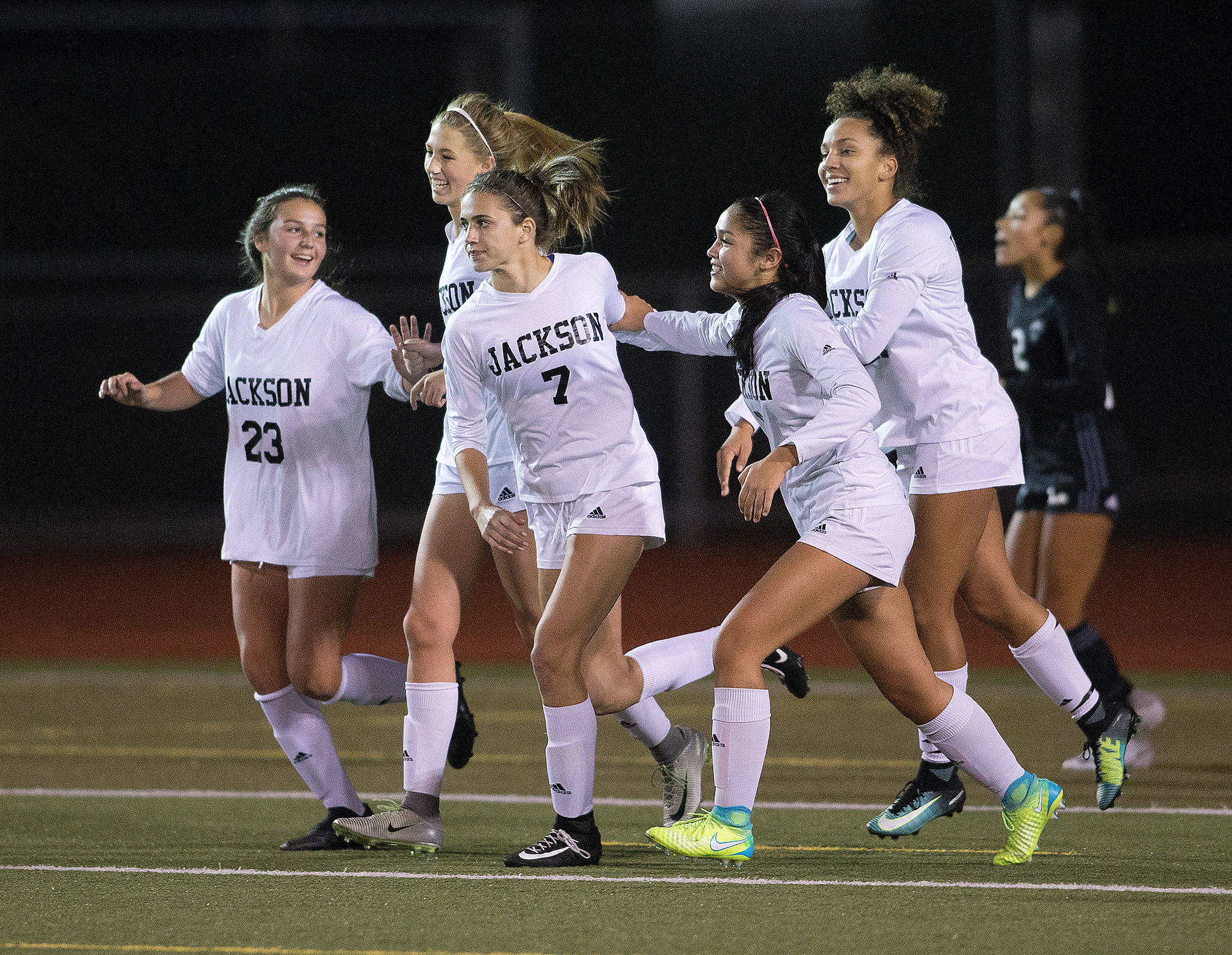 Jackson High’s Keile Hansen (7) is congratulated by teammates after scoring a goal in the first half as the Timberwolves took on Union High School in a girls’ soccer match at Everett Memorial Stadium on Tuesday, Nov. 7, 2017 in Everett, Wa. (Andy Bronson / The Herald)