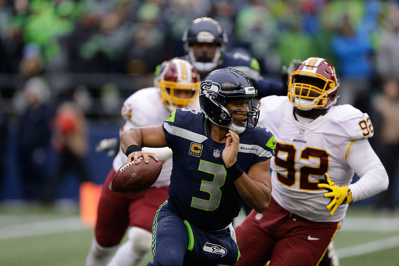 Seahawks quarterback Russell Wilson (3) scrambles away from Redskins defensive end Stacy McGee (92) in the second half of a game Nov. 5, 2017, in Seattle. (AP Photo/Stephen Brashear)