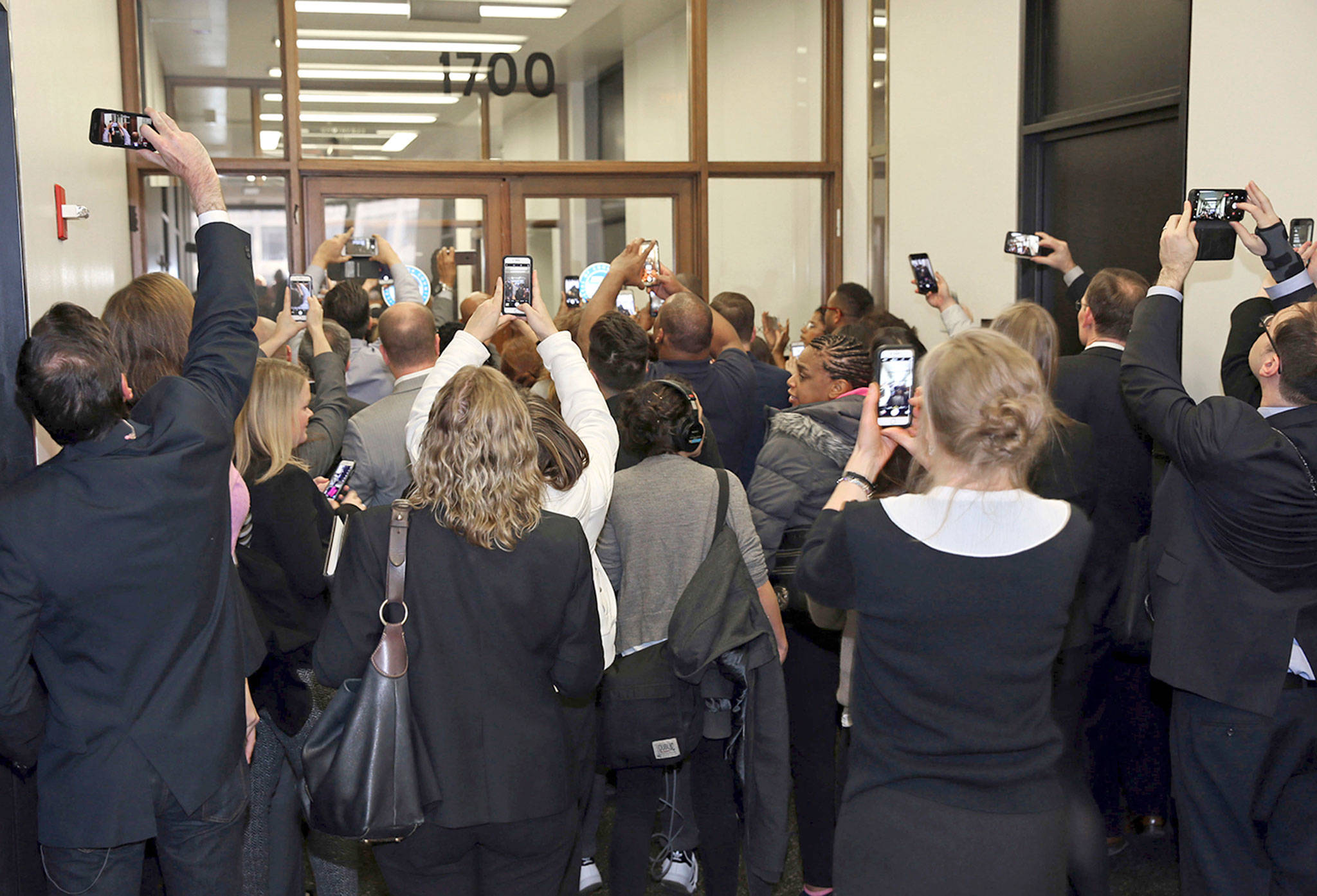 People rush the doors of the jury assembly room as former President Barack Obama arrives for jury duty in the Daley Center on Wednesday in Chicago. (Kevin Tanaka/Sun Times via AP)