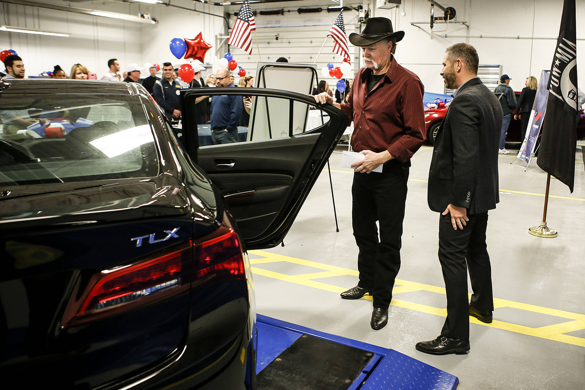 Eric Andrew Prescott, a veteran of the U.S. Marine Corps, checks out the Acura TLX given to him as part of a program put on by Progressive Insurance to donate refurbished cars to veterans during an event at the company’s Lynnwood service center on Thursday. (Ian Terry / The Herald)