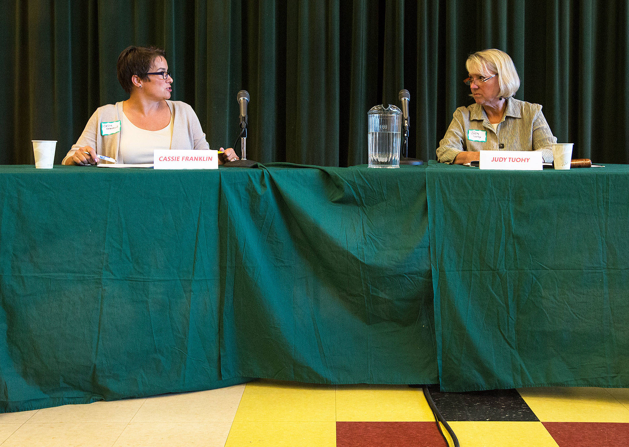 Cassie Franklin (left) and Judy Tuohy chat before answering questions during an Everett mayoral debate in September. (Andy Bronson / The Herald)