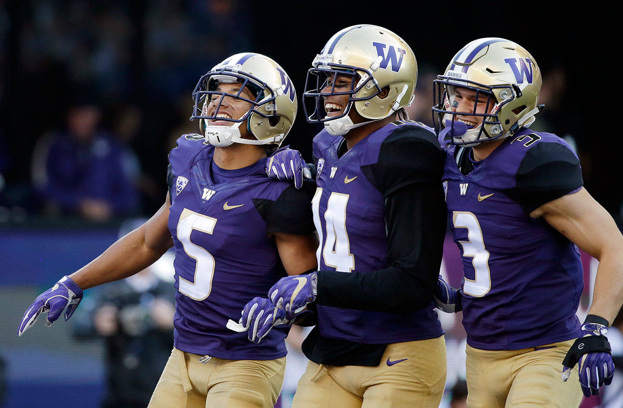 Washington’s Myles Bryant (5) celebrates with JoJo McIntosh (14) and Elijah Molden after Bryant’s recovery of a UCLA fumble in the second half of a game Oct. 28, 2017, in Seattle. (AP Photo/Elaine Thompson)