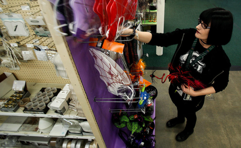 At Everett Display & Costume Monday, floor manager Christine Crosbie straightens and organizes discounted merchandise. (Dan Bates / The Herald)
