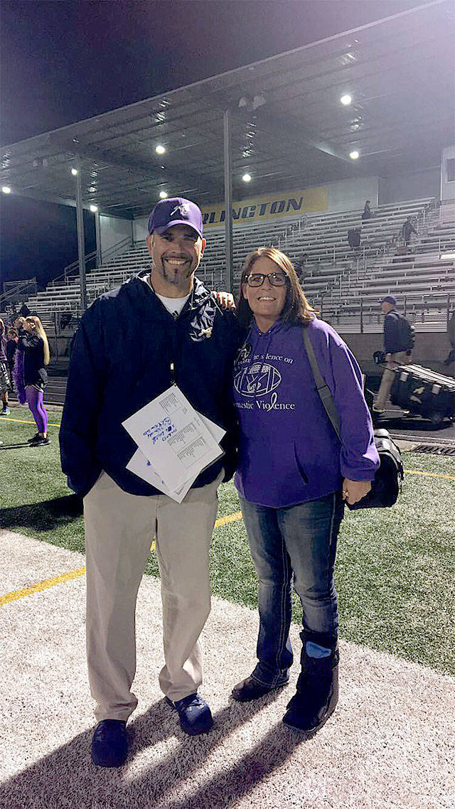 Arlington High School football coach Greg Dailer (left) worked with community volunteer Tracy Van Beek to raise awareness of domestic violence issues at a Sept. 29 home game. (Contributed photo)