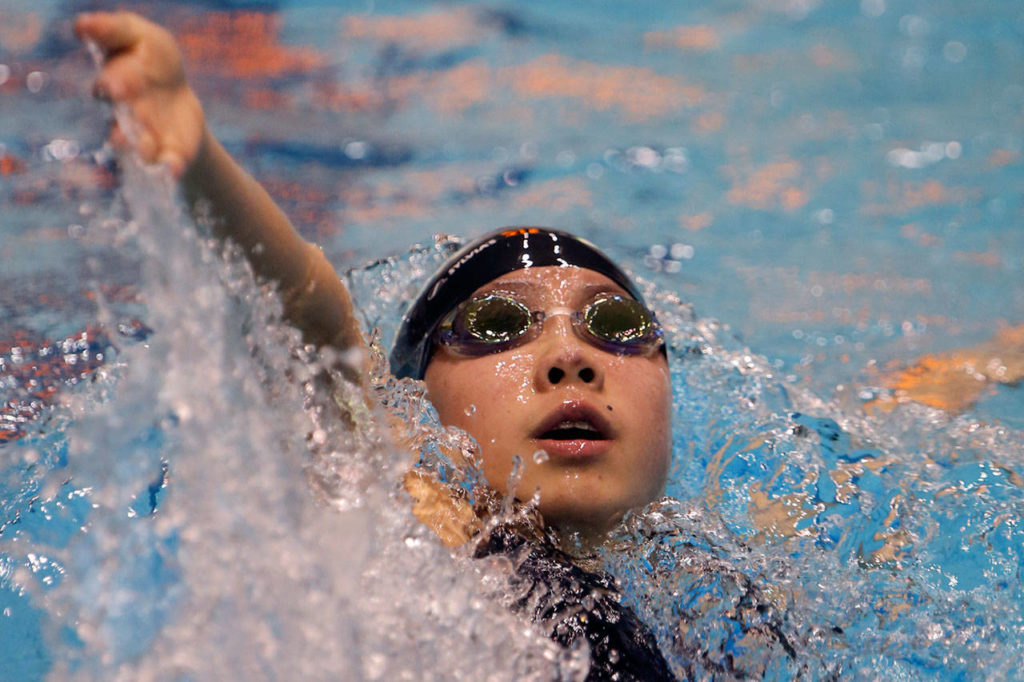 Jackson’s Mia Chang competes in the 100-yard backstroke during the 4A state swim and dive championships on Nov. 11, 2017, at the King County Aquatic Center in Federal Way. Change finished third in the event. (Kevin Clark / The Herald)

