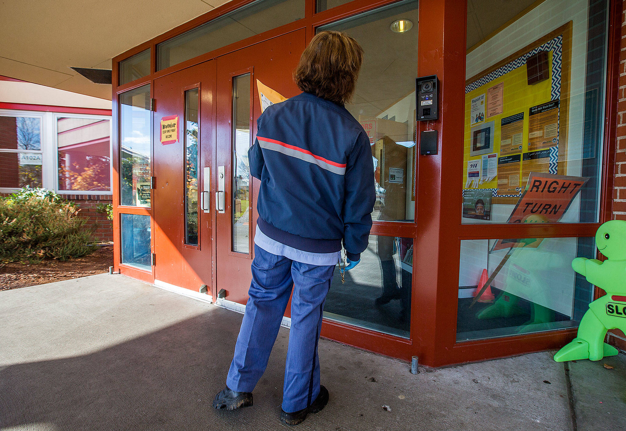 Andy Bronson / The Herald                                After pushing a button, postal carrier Sheri Boober announces herself in front of video camera Friday at Hawthorne Elementary in Everett. Now anyone wanting to enter the school has to be buzzed in after using the intercom system.