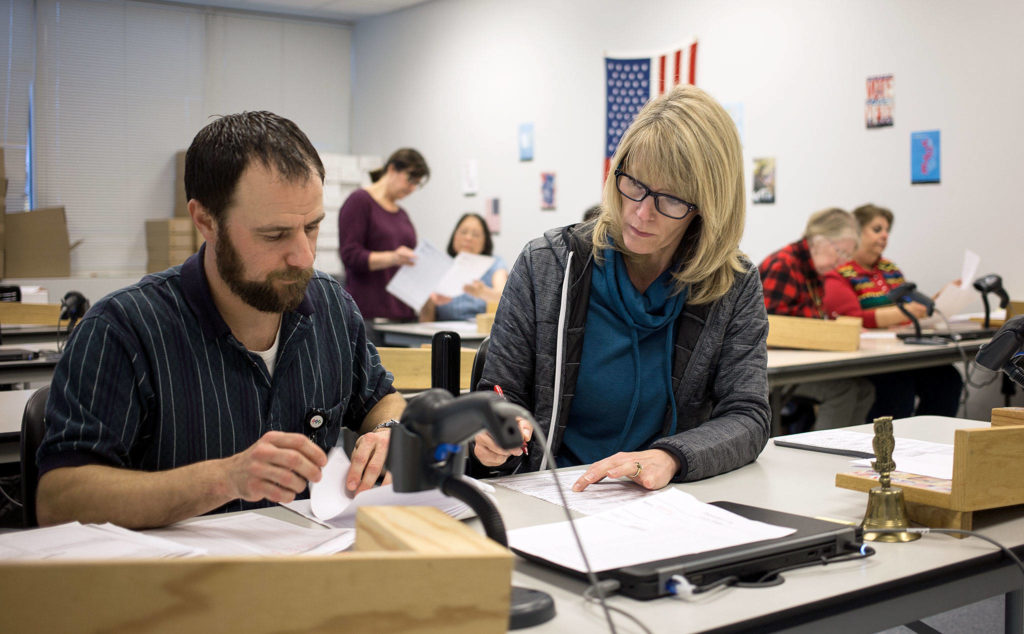 Workers process duplicate ballots at the Elections Processing Center Jackson House on Tuesday in Everett. (Andy Bronson / The Herald)

