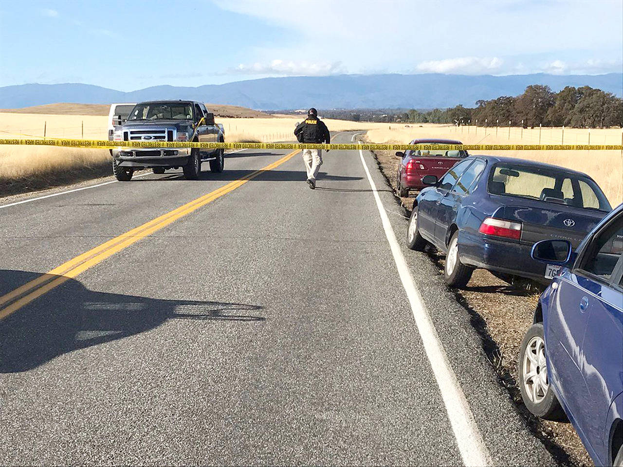 Crime tape blocks off Rancho Tehama Road leading into the Rancho Tehama subdivision south of Red Bluff, California, following a fatal shooting on Tuesday. (Jim Schultz/The Record Searchlight via AP)