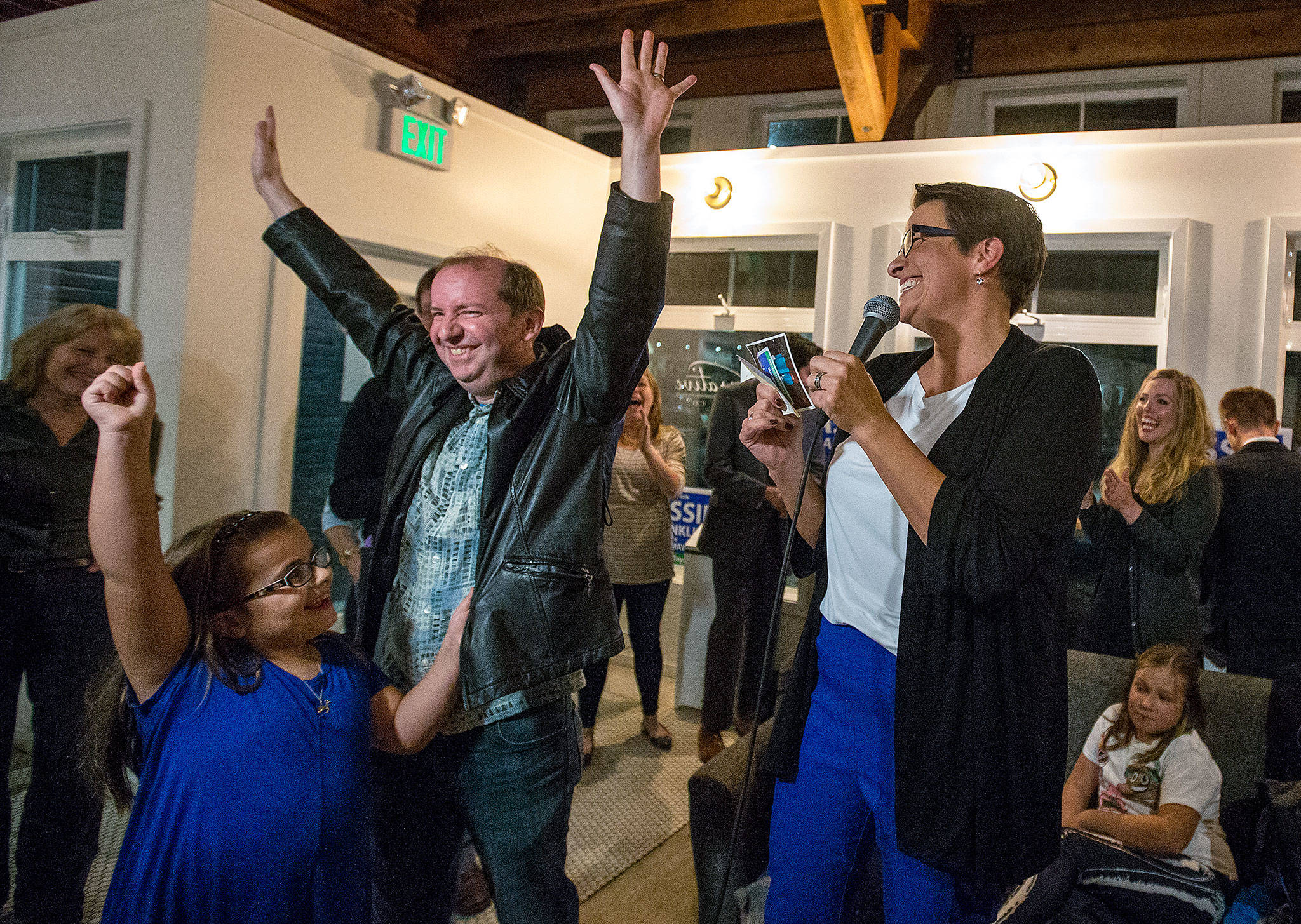 Cassie Franklin (right) is cheered by her daughter, Panda, and husband, David, as the Everett mayoral candidate thanked them and supporters on election night at Narrative Coffee in Everett. (Andy Bronson / The Herald)