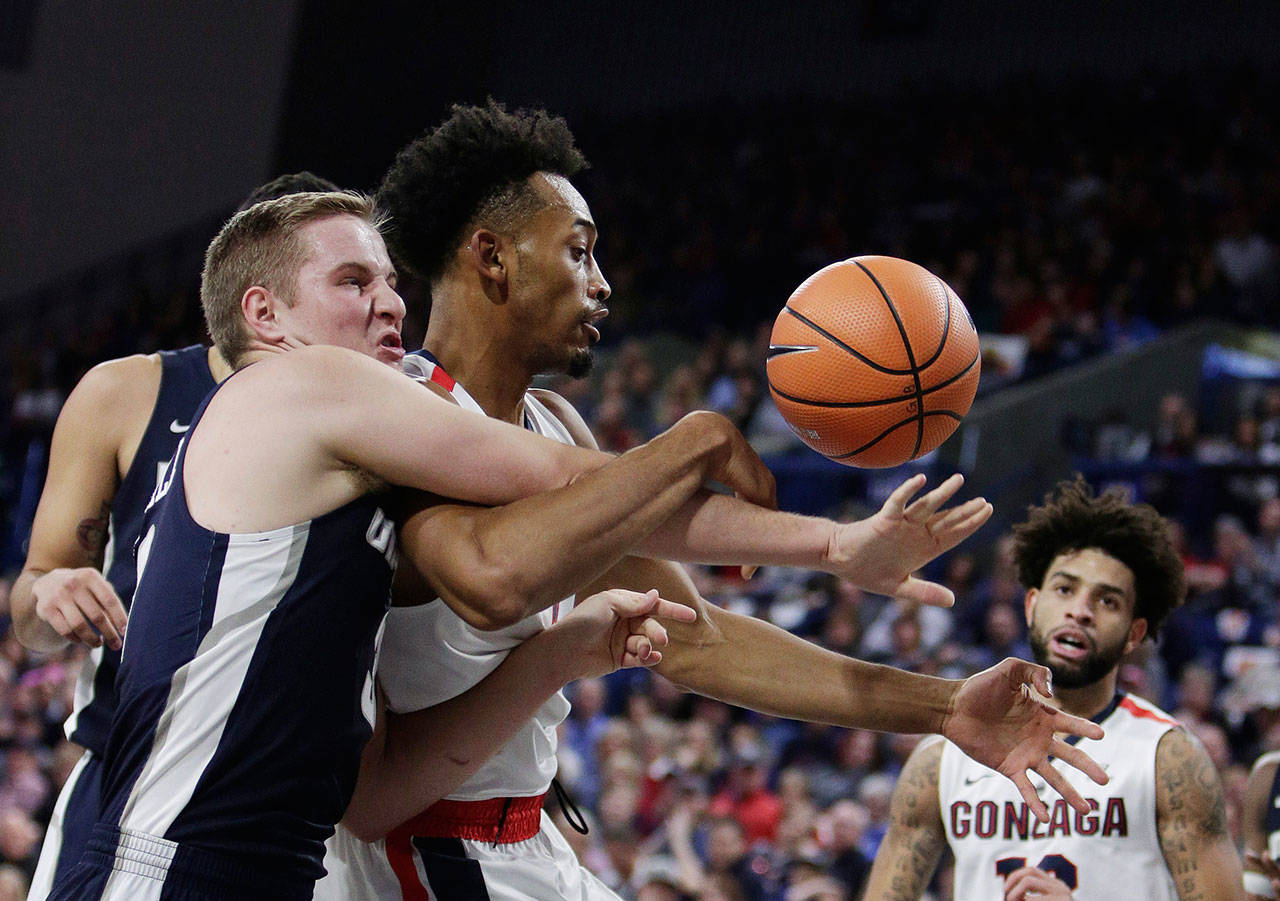 Utah State guard Sam Merrill (left) and Gonzaga forward Johnathan Williams go after a rebound during the first half of a game on Nov. 18, 2017, in Spokane. (AP Photo/Young Kwak)