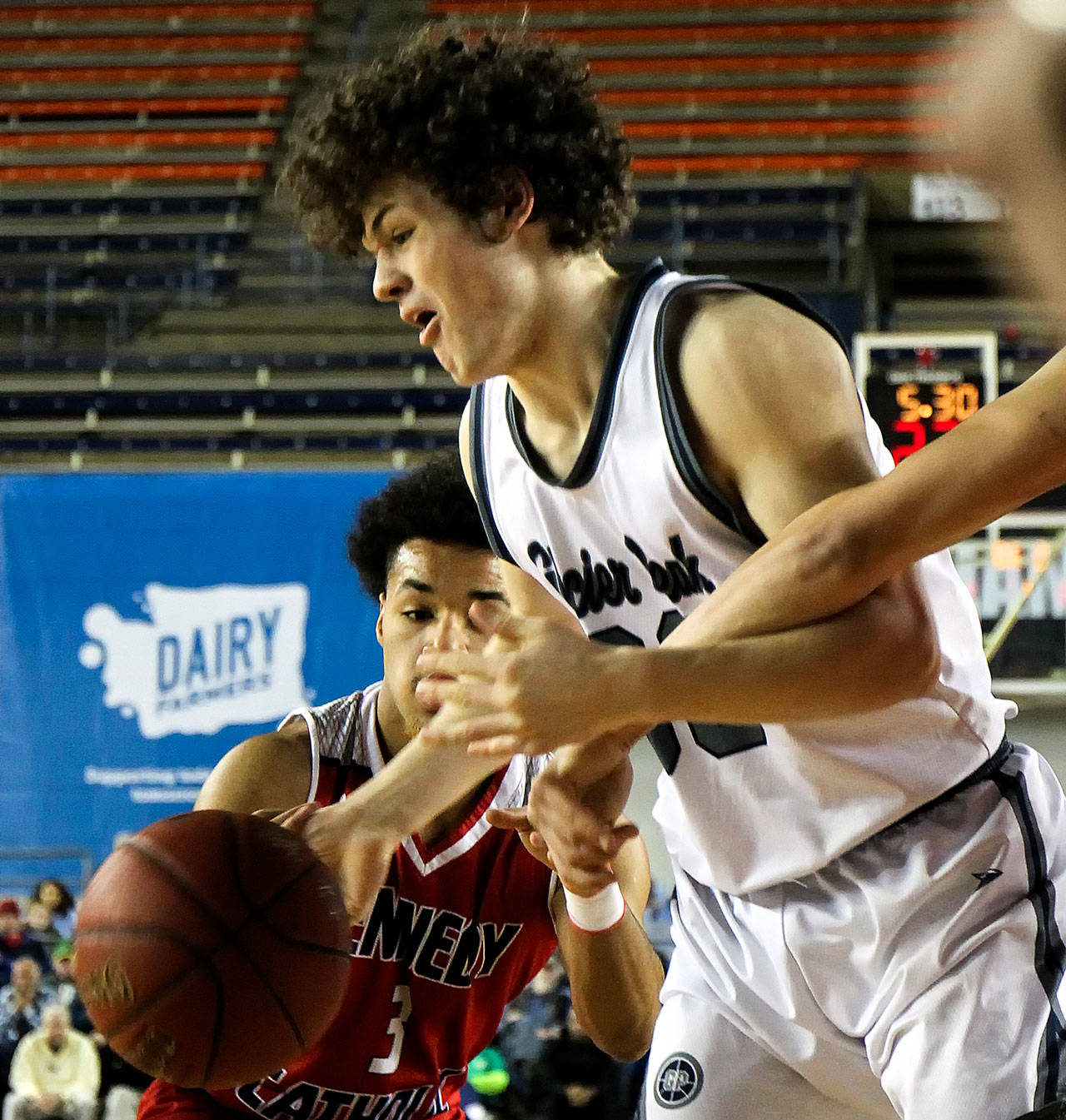 Kennedy Catholic’s Keannu Royster (left) and Glacier Peak’s Bobby Martin chase a loose ball March 1 during a 2017 4A Hardwood Classic game in Tacoma. (Kevin Clark / The Herald)