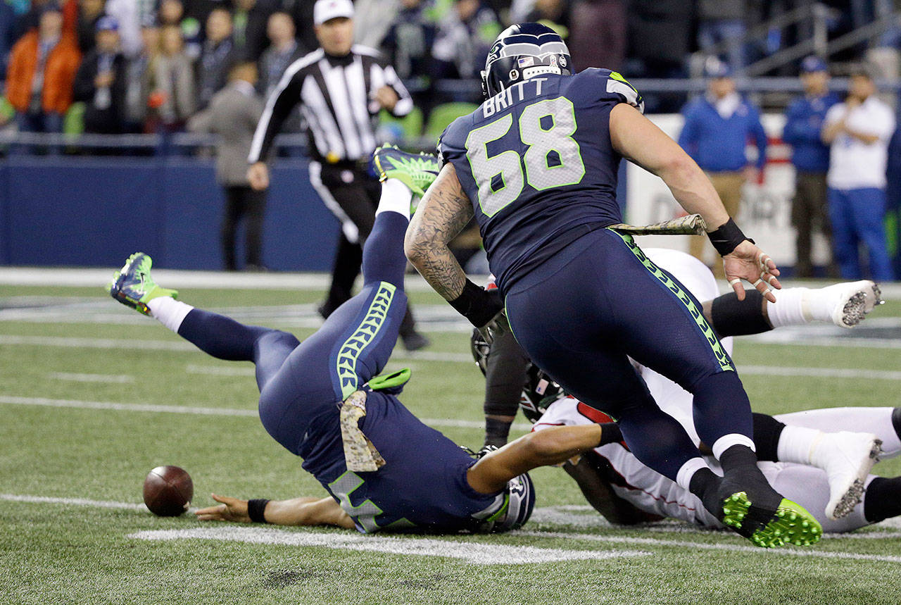 Seattle quarterback Russell Wilson fumbles the ball after he is sacked by Atlanta’s defense during the first half of the Seahawks’ 34-31 loss to the Falcons on Monday at CenturyLink Field in Seattle. (AP Photo/Ted S. Warren)