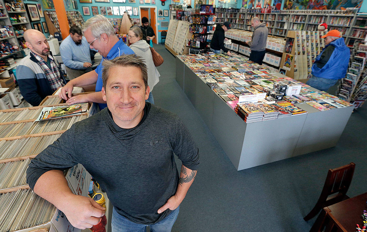 John Dudas, owner of Carol and John’s Comic Book Shop, poses during New Comic Day in Cleveland. (AP Photo/Tony Dejak)