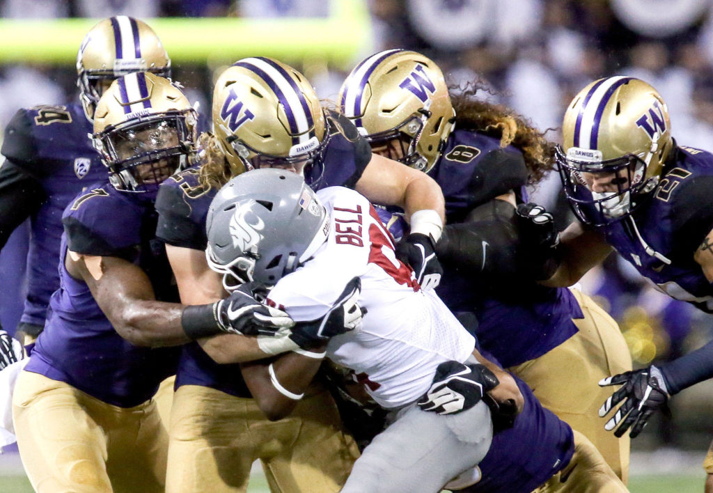 Washington State Cougars wide receiver Renard Bell is met with defensive pressure Saturday night during the 110th Apple Cup at Husky Stadium in Seattle November 25, 2017. Washington won 41-14. (Kevin Clark / The Herald)
