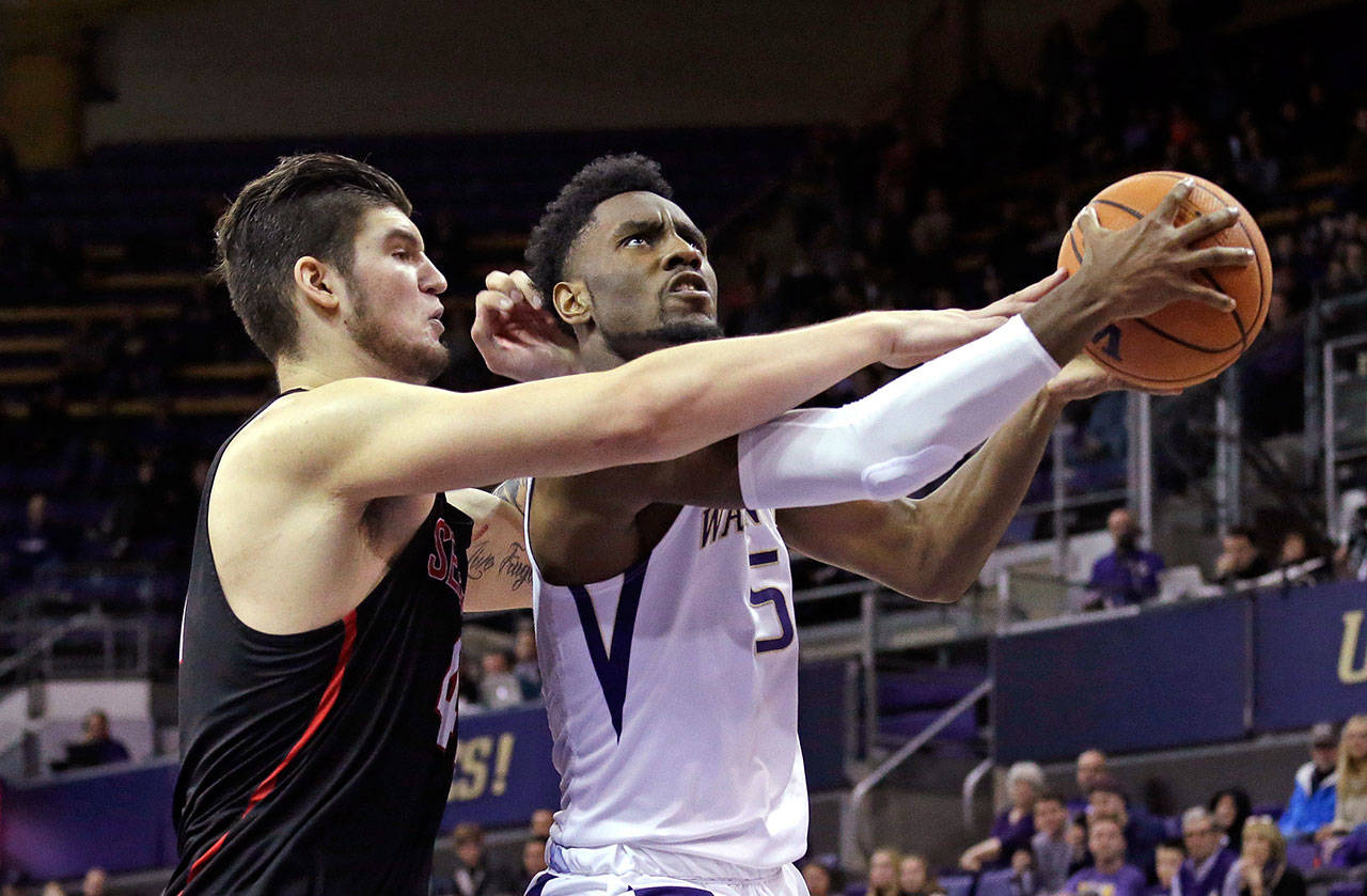 Seattle’s Aaron Menzies (left) fouls Washington’s Jaylen Nowell in the last minute of a game on Nov. 24, 2017, in Seattle. (AP Photo/Elaine Thompson)