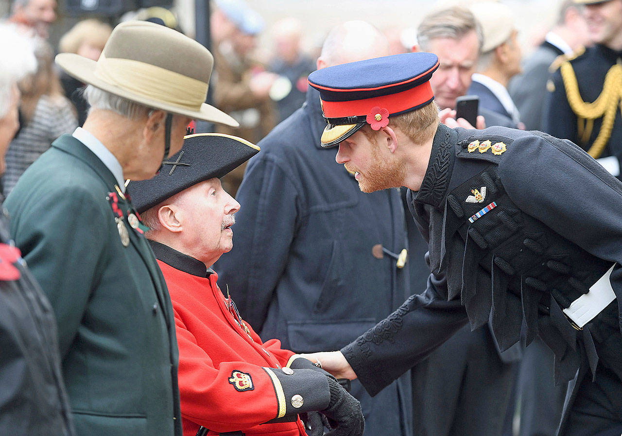 Britains Prince Harry meets veterans during a ceremony honoring the fallen Nov. 9 at Westminster Abbey Field of Remembrance in London. (AP Photo/Jeremy Selwyn)