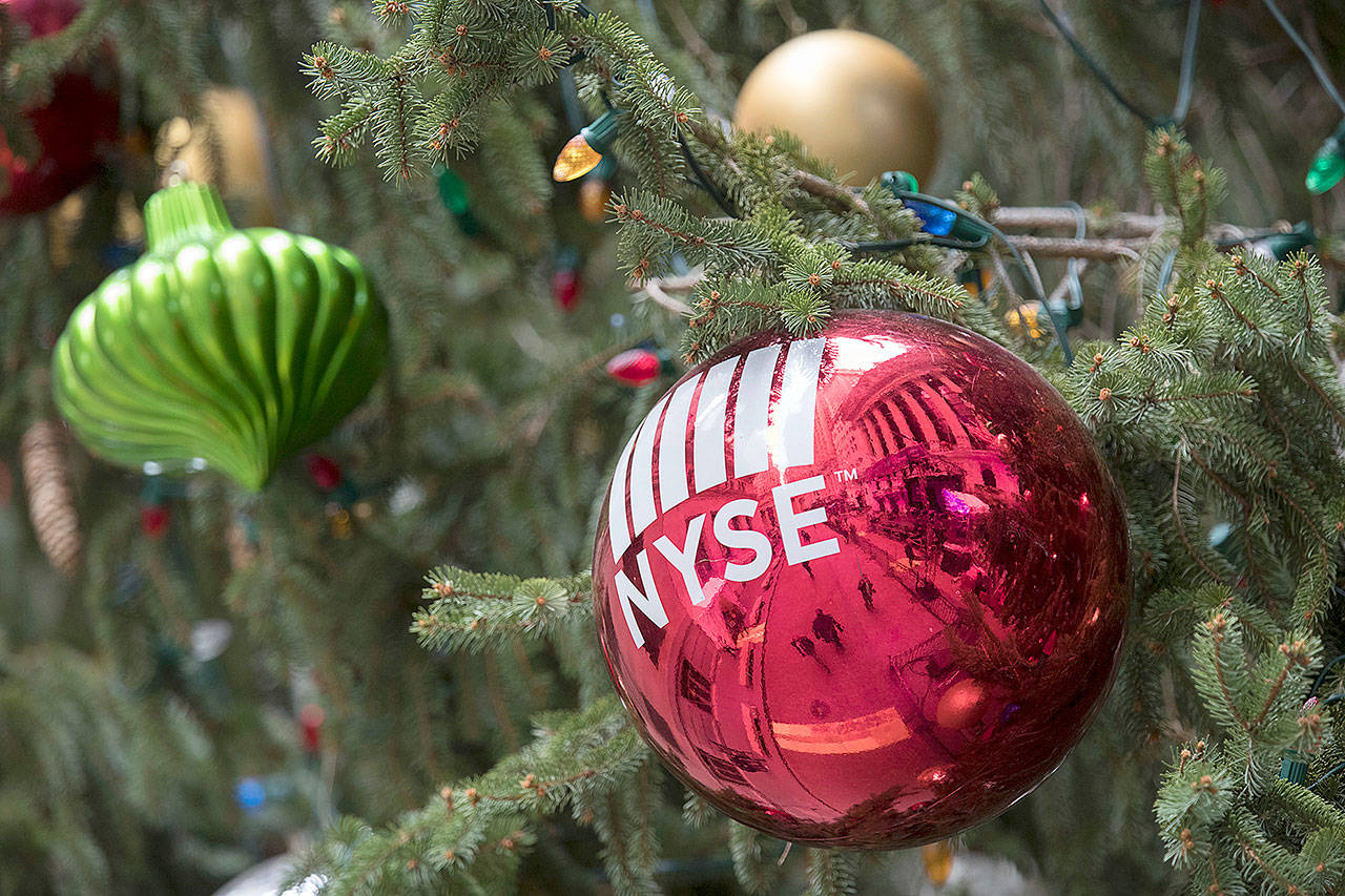 The New York Stock Exchange is seen reflected on an ornament hanging on a Christmas tree outside the exchange Thursday in New York. (AP Photo/Mary Altaffer)