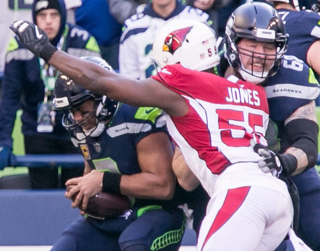 Seahawks quarterback Russell Wilson is sacked by Cardinals linebacker Chandler Jones with Seahawks offensive lineman Justin Britt pushing back Sunday afternoon at CenturyLink Field in Seattle on December 31, 2017. Seattle lost 26-24. (Kevin Clark / The Daily Herald)
