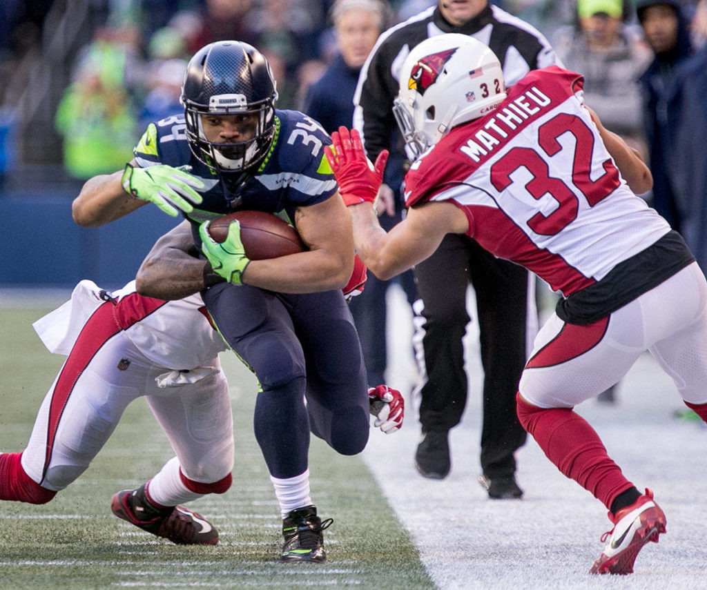 Seahawks running back Thomas Rawls rushes with Cardinals safety Rudy Ford tackling and Cardinals safety Tyrann Mathieu, right, closing Sunday afternoon at CenturyLink Field in Seattle on December 31, 2017. Seattle lost 26-24. (Kevin Clark / The Daily Herald)
