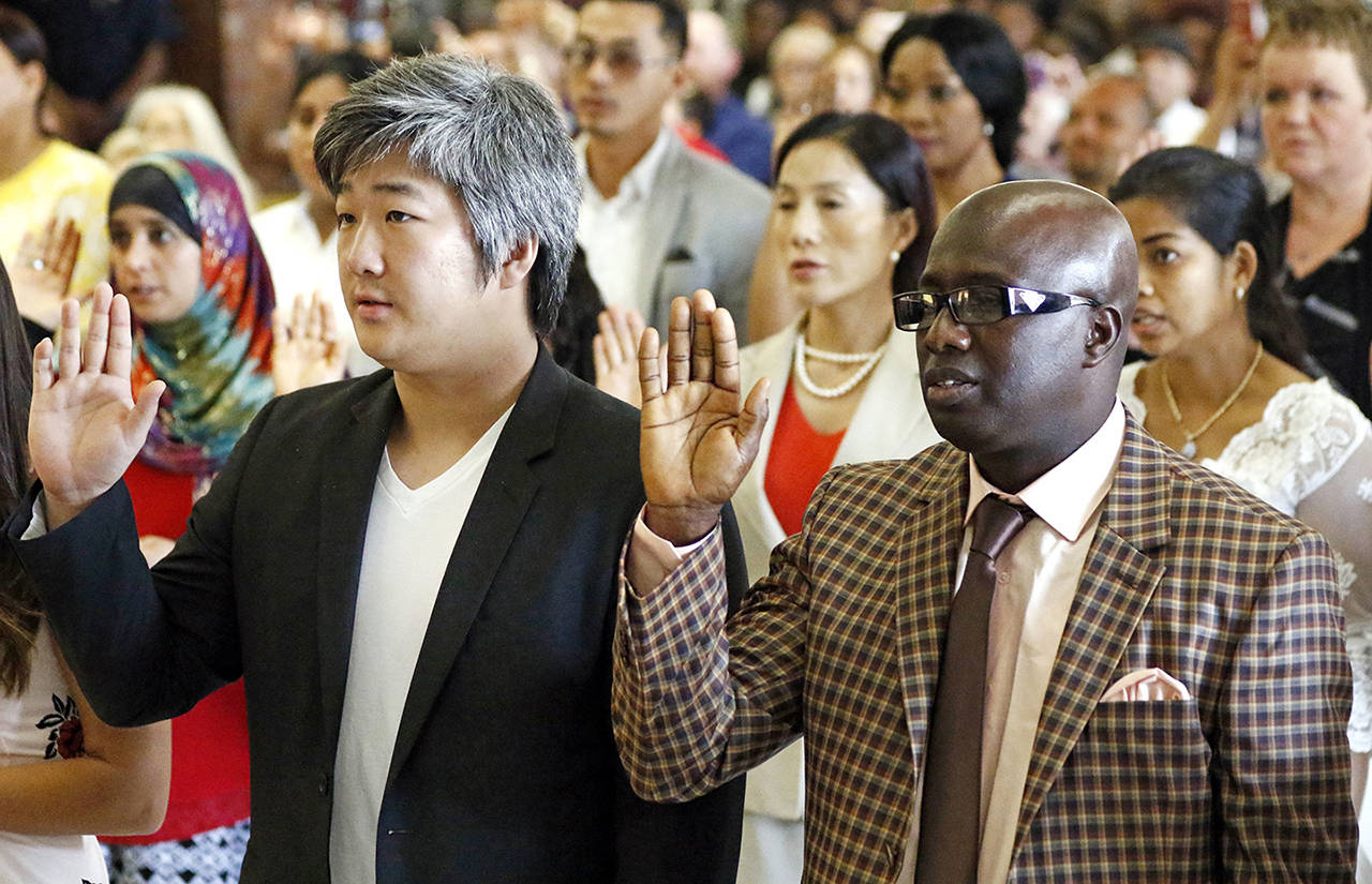 In this Sept. 18 photo, 35 immigrants from 23 countries recited the Oath of Allegiance during the naturalization ceremony in Jackson, Mississippi. (AP Photo/Rogelio V. Solis File)