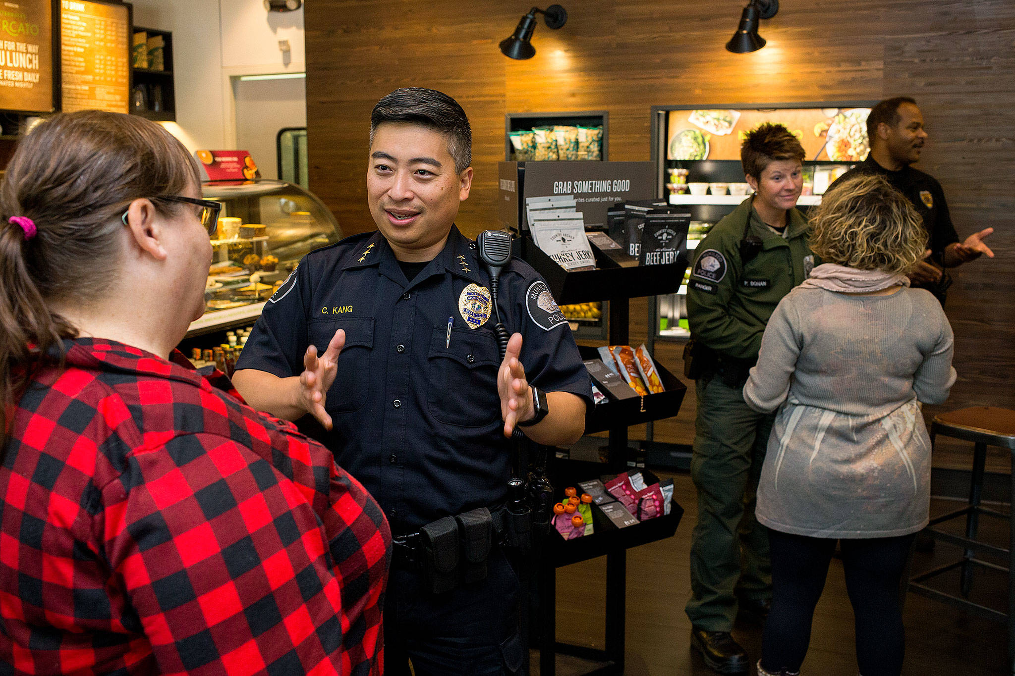 Mukilteo Police Chief Cheol Kang talks with Tracey Johnson, left, during a “Coffee With A Cop” event at Starbucks on Mukilteo Speedway. (Andy Bronson / The Herald)