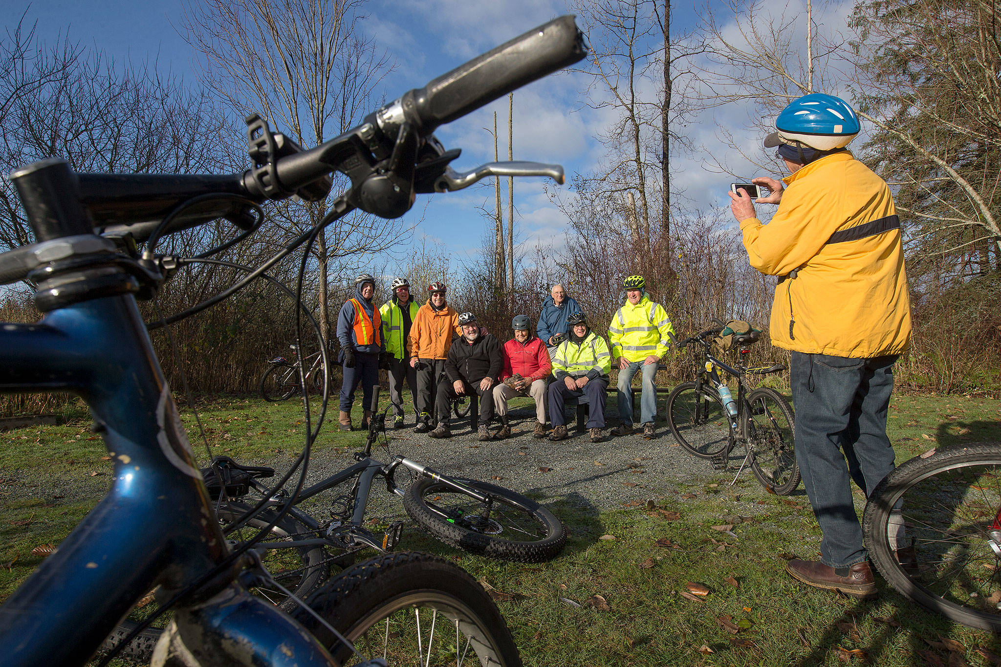 Jerry Solie takes a picture of the group as the cyclists stop to rest after biking from Arlington to Lake Cassidy via the Centennial Trail on Dec. 4 in Arlington. (Andy Bronson / The Herald)