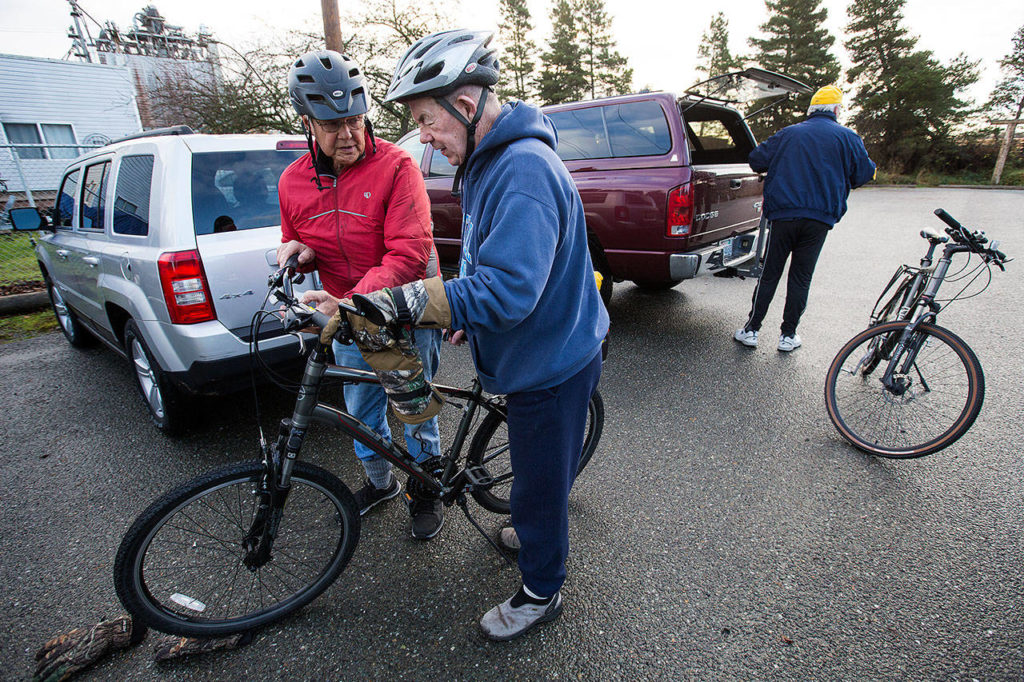 David Lande (left) explains what is wrong with Larry O’Donnell’s bike computer before they ride to Mount Vernon from Conway on Nov. 27. (Andy Bronson / The Herald)
