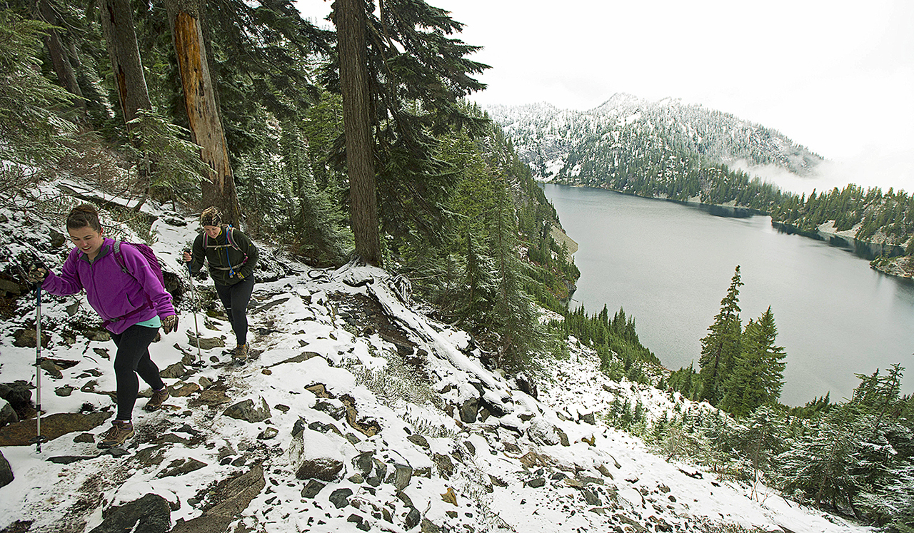 In this Nov. 3, 2015, file photo, Kasee Palmer, left, and Summer Sturhan hike on Snow Lake Trail above Snoqualmie Pass in Washington state. (AP Photo/Ted S. Warren, File)