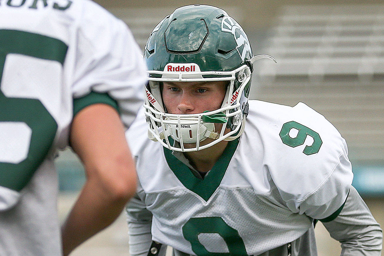 Noah Becker, defensive back, eyes the ball held by Jack Kramer during drills Wednesday afternoon at Edmonds-Woodway High School in Edmonds on October 11th, 2017. (Kevin Clark / The Herald)