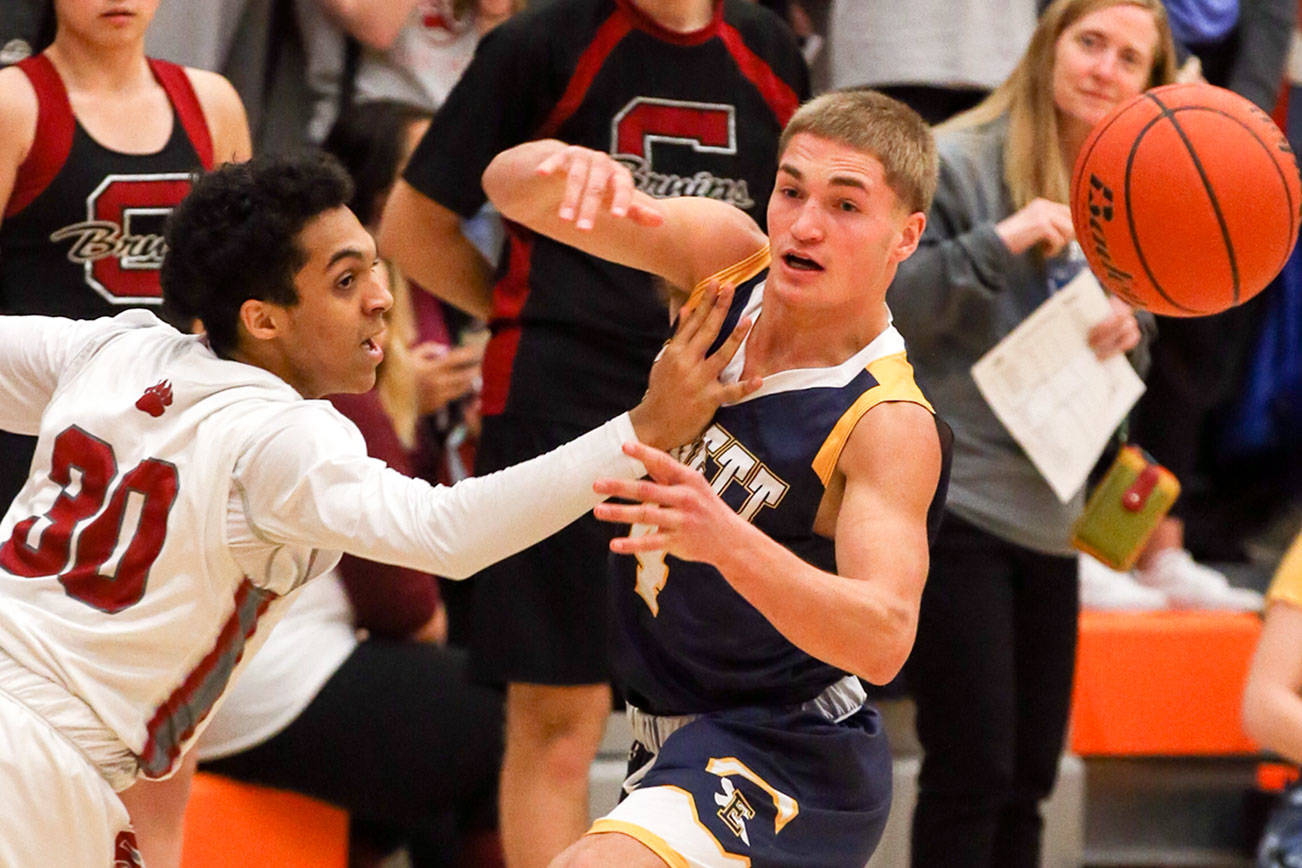 Cascade’s Dezmond Tyler-Davis, left, and Everett’s Bogdan Fesiienko vie for a loose ball Friday night at Everett Community College in Everett on December 1, 2017. (Kevin Clark / The Herald)