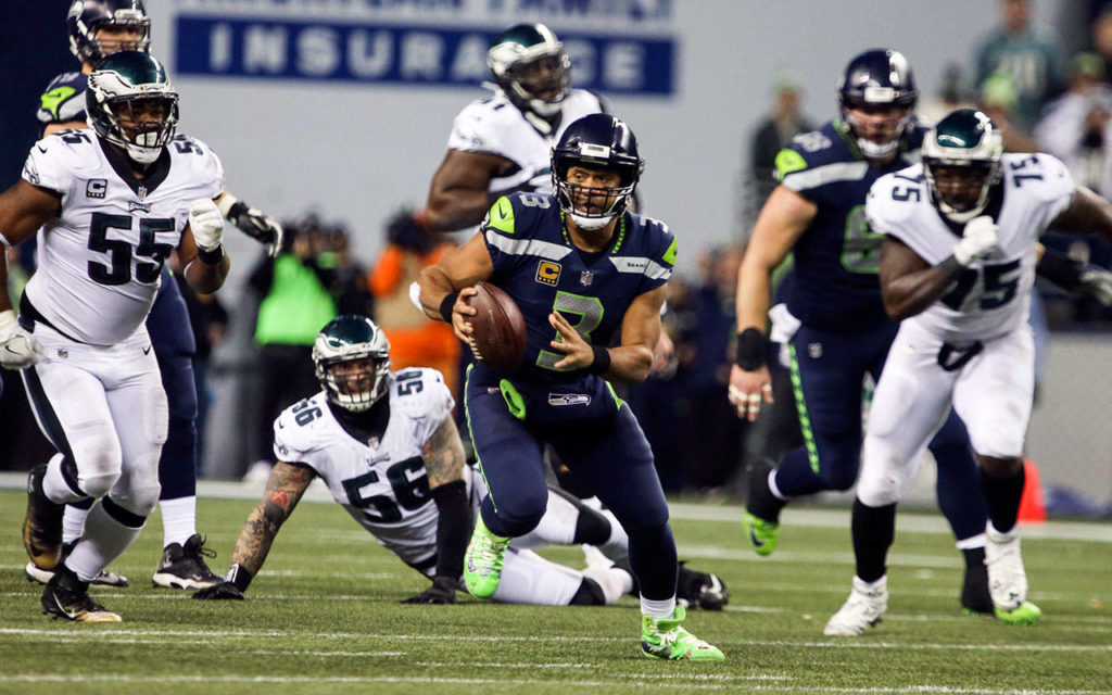 Seahawks quarterback Russell Wilson scrambles with the Eagles giving chase Sunday night at CenturyLink Field in Seattle on December 3, 2017. Seattle won 24-10. (Kevin Clark / The Herald)
