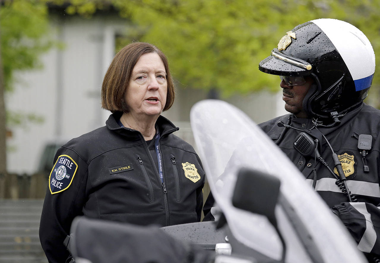 In this May 1 photo, Seattle Police Chief Kathleen O’Toole (left) talks with an officer before a march for worker and immigrant rights at a May Day event in Seattle. (AP Photo/Elaine Thompson, File)
