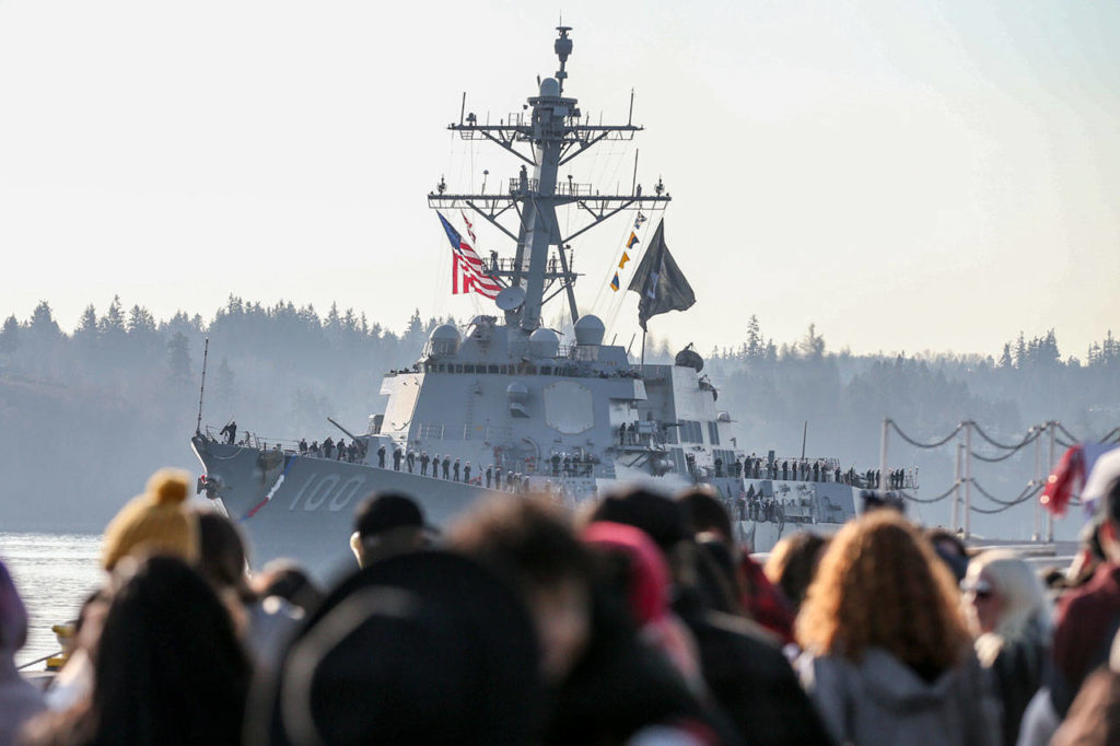 The U.S.S. Kidd motors toward its berth Sunday morning, as family and friends wait at the Naval Station Everett. (Kevin Clark / The Herald)

