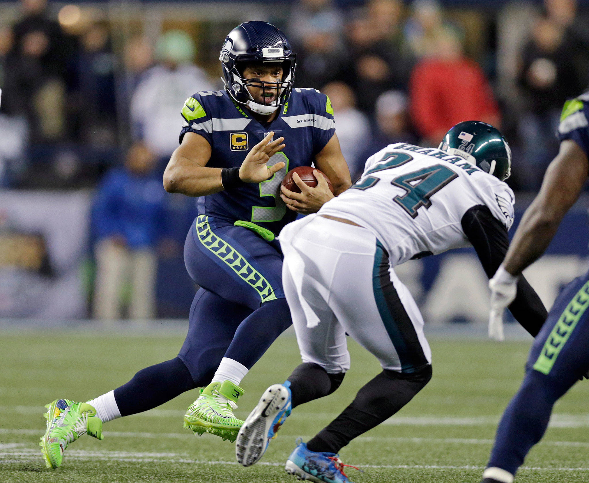 Seahawks quarterback Russell Wilson (left) scrambles as the Eagles’ Corey Graham (24) closes in during the first half of a game Dec. 3, 2017, in Seattle. (AP Photo/John Froschauer)