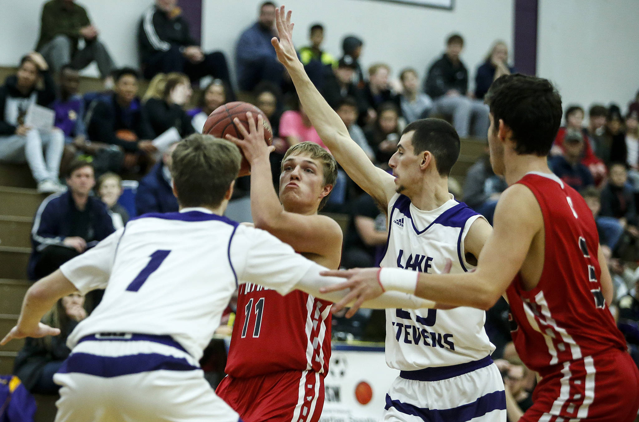 Stanwood’s Karl DeBoer (center) shoots as Lake Stevens’ Garrett Kraxberger (left) and Derik Myers (second from right) defend and Stanwood’s Matt Vail (far right) looks on during a game Dec. 5, 2017, at Lake Stevens High School. (Ian Terry / The Herald)