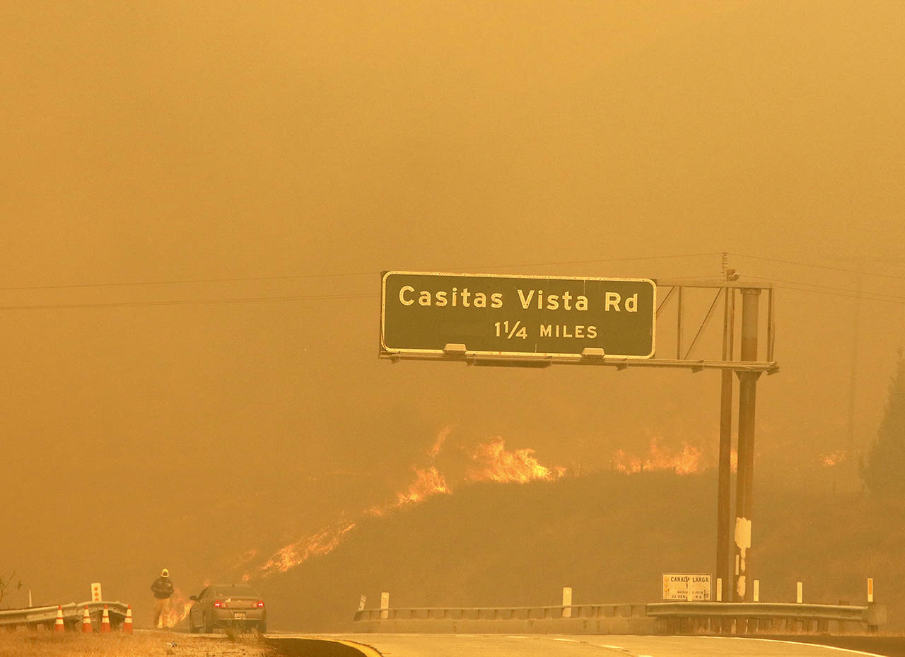 Flames and smoke shroud State Route 33 as a wildfire burns in Ventura, California, on Tuesday. (Daniel Dreifuss via AP)