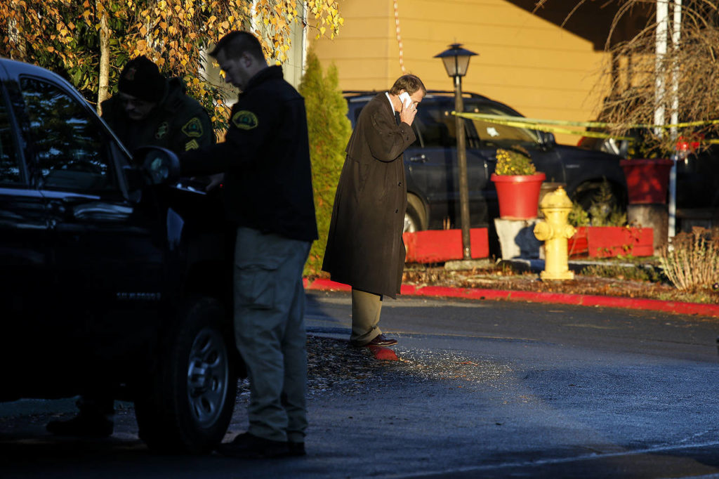 Investigators and law enforcement work near the scene of a shooting at a home in the Village Green Mobile Home Park near East Gibson Road in south Everett. A 54-year old woman was killed and a 17-year old male was injured. (Ian Terry / The Herald)
