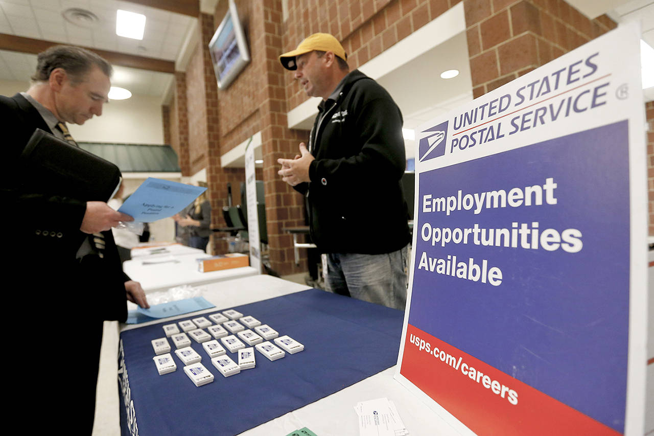 In this Nov. 2 photo, a recruiter from the postal service (right) speaks with an attendee of a job fair in Cheswick, Pennsylvania. (AP Photo/Keith Srakocic)