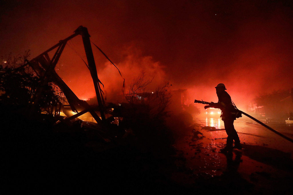 Fire crews work among destroyed homes at the Rancho Monserate Country Club community Thursday in Fallbrook, California. (AP Photo/Gregory Bull)
