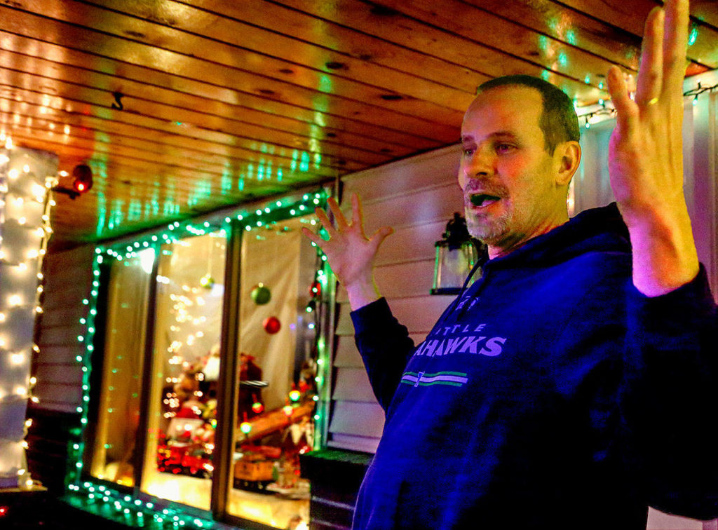 Inspired by old-fashioned store windows, the home of Kirk and Melissa Slightam has this scene that evokes the movie “A Christmas Story.” At right, Kirk says that when he and Melissa were house hunting and discovered this home was in “that Christmas light neighborhood,” they had to have it. (Dan Bates / The Herald)
